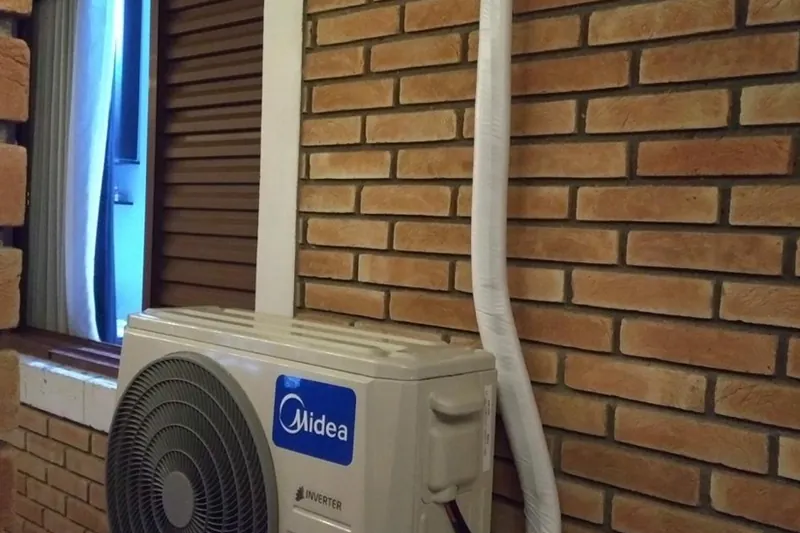 Condensadora instalada em parede de tijolo, com tubulação embutida em canaleta