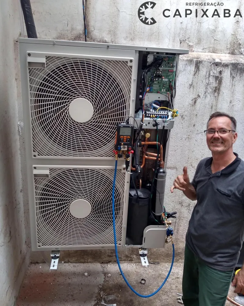 Técnico ao lado de uma condensadora aberta para reparo